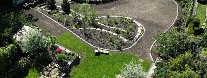 VOLLSTÄNDIGE NEUGESTALTUNG Blick von oben auf einen Park ähnlich angelegten Garten mit Beeten, Rasenflächen und Wegen