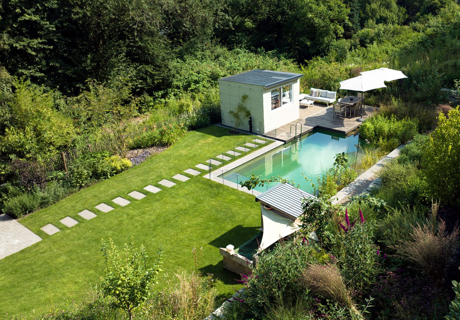 Naturpool mit großzügiger Terrasse, viel Grün und Rasenfläche, Blick von oben
