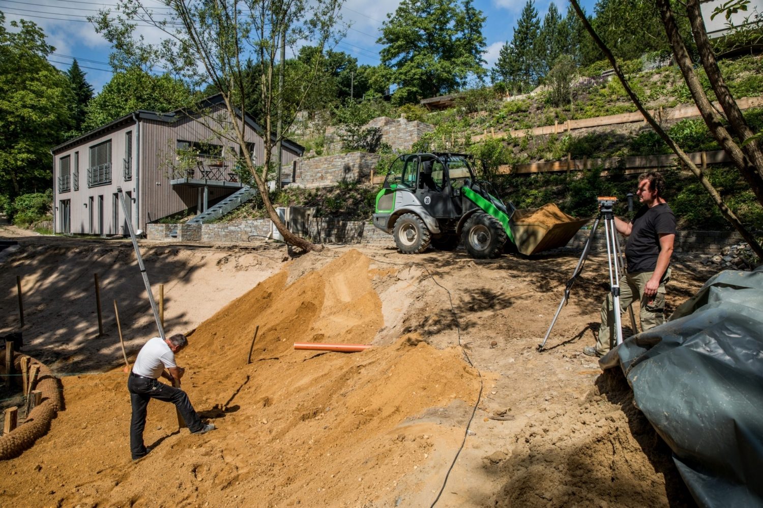 Gartenbaustelle mit Bagger und Gartenbauern