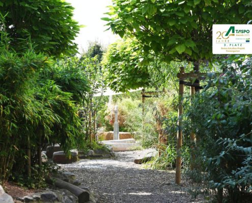 Abenteuerpfad auf dem Kita-Spielplatz Sicht auf einen Spielplatzpfad mit Totholz und Stauden