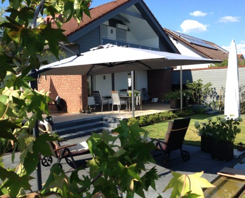 Ein kleiner Hausgarten mit Terrasse aus Naturstein