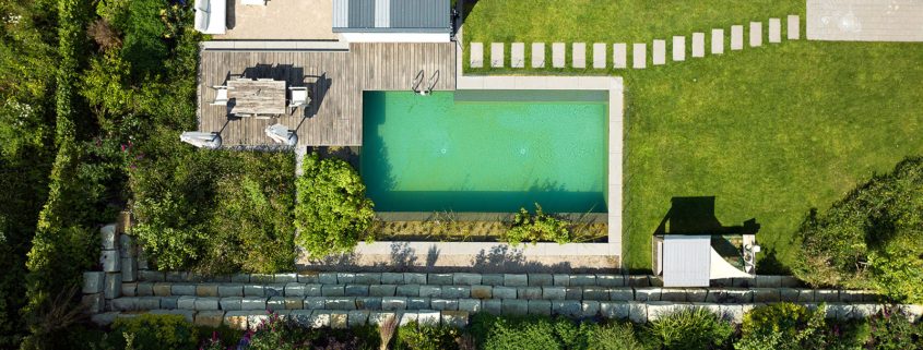 Naturpool Luftaufnahme Aufnahmen von oben auf einen Naturpool, einem Holzdeck mit Sitzgelegenheit und Gehölzbeete